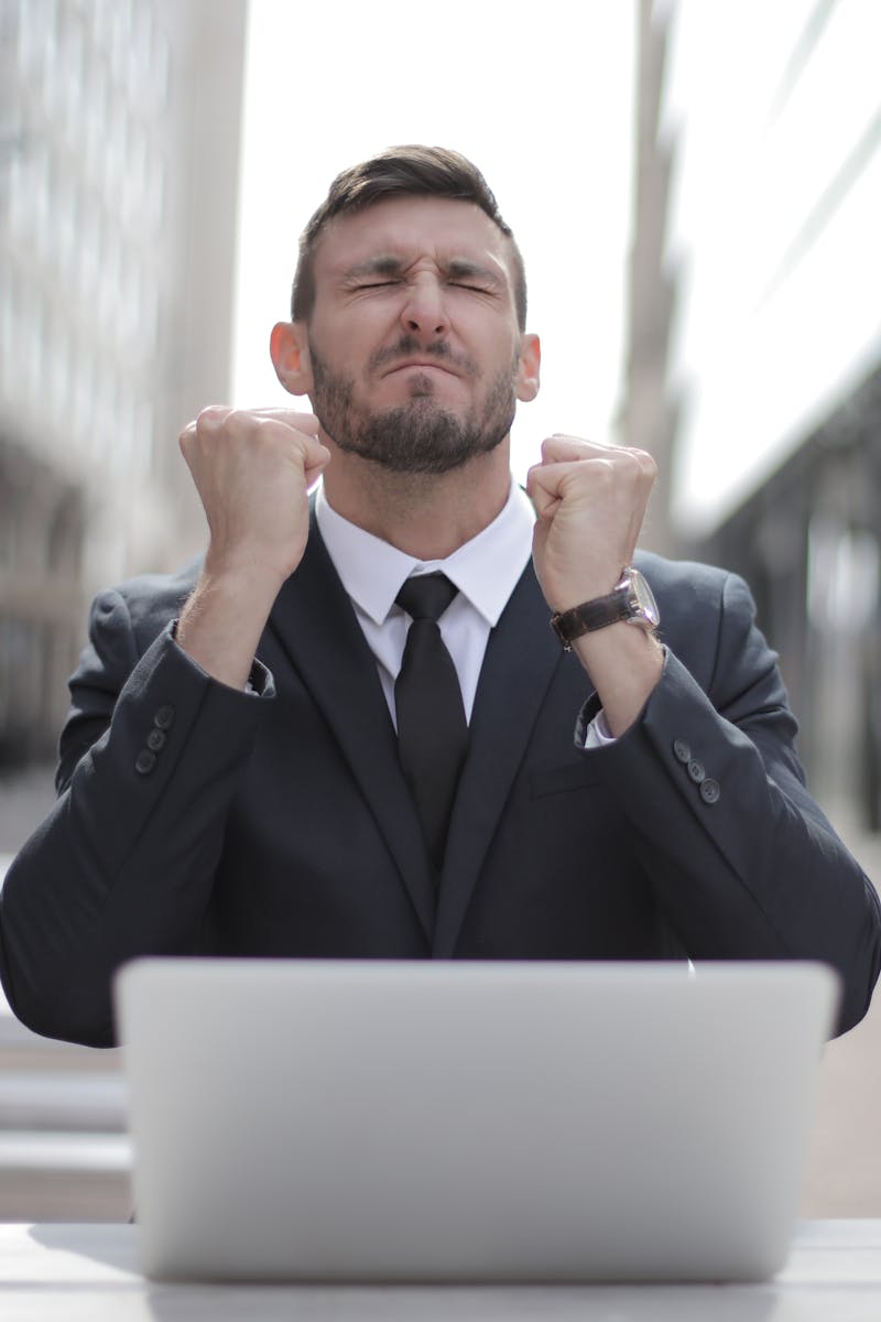 Confident businessman in Budapest celebrates success with a fist pump, reflecting a professional achievement.